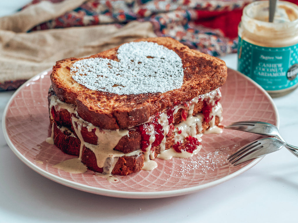 Stack of french toast with Butter Nut of London Cashew Coconut Cardamom nut butter and Raspberry Jam bursting out.