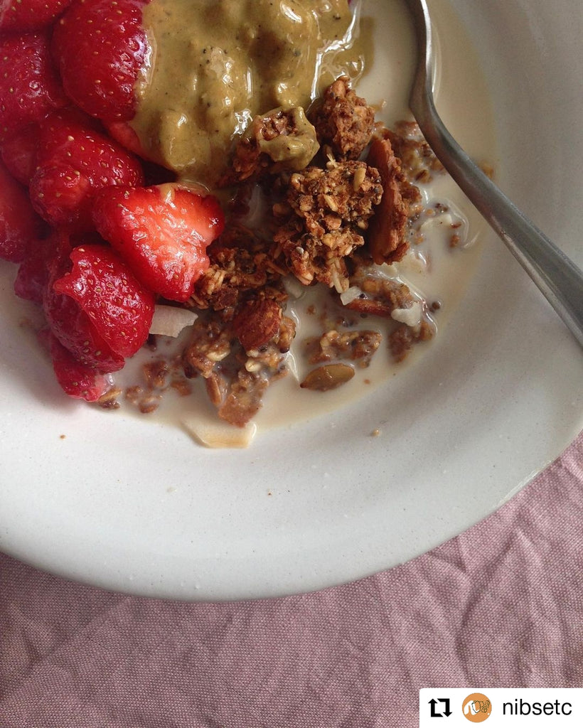 Nibs Etc. granola topped with fresh strawberries and Butter Nut of London's Pistachio & Rose nut butter | Photo by @nibsetc