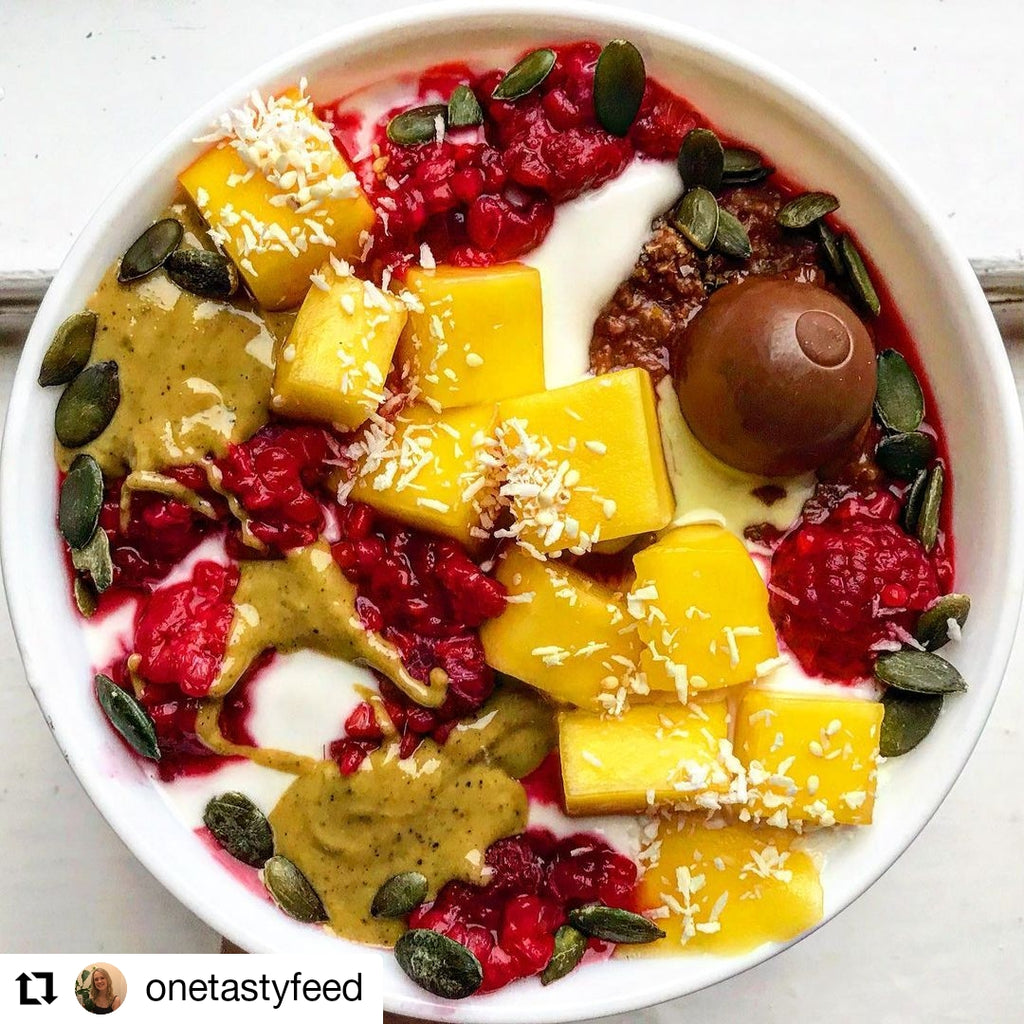 Porridge toppedwith pumpkin seeds, raspberries, mango dessicated coconut and Butter Nut of London's Pistachio & Rose nut butter | Photo by @onetastyfeed